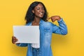 Beautiful african young woman holding blank empty banner pointing finger to one self smiling happy and proud Royalty Free Stock Photo