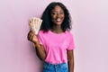 Beautiful african young woman holding 10 united kingdom pounds banknotes looking positive and happy standing and smiling with a