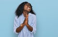Beautiful african young woman wearing casual clothes and glasses begging and praying with hands together with hope expression on Royalty Free Stock Photo