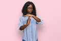 Beautiful african young woman wearing casual clothes and glasses doing time out gesture with hands, frustrated and serious face Royalty Free Stock Photo
