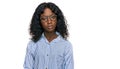 Beautiful african young woman wearing casual clothes and glasses relaxed with serious expression on face Royalty Free Stock Photo