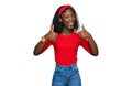 Beautiful african young woman wearing casual clothes success sign doing positive gesture with hand, thumbs up smiling and happy Royalty Free Stock Photo