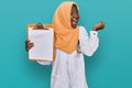 Beautiful african young woman wearing doctor stethoscope holding clipboard screaming proud, celebrating victory and success very Royalty Free Stock Photo