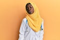 Beautiful african young woman wearing doctor uniform and hijab looking at the camera blowing a kiss on air being lovely and sexy Royalty Free Stock Photo