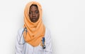 Beautiful african young woman wearing doctor uniform and hijab with serious expression on face Royalty Free Stock Photo