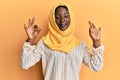 Beautiful african young woman wearing traditional islamic hijab scarf relax and smiling with eyes closed doing meditation gesture Royalty Free Stock Photo