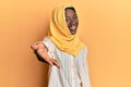 Beautiful african young woman wearing traditional islamic hijab scarf smiling friendly offering handshake as greeting and