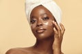Beautiful Afro-american woman applying under eye patches. Royalty Free Stock Photo