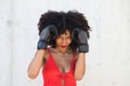 Beautiful Afro-American woman with boxing gloves claiming women`s rights against mistreatment and breast cancer. Concept of women