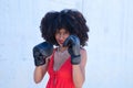 Beautiful Afro-American woman with boxing gloves claiming women`s rights against mistreatment and breast cancer. Concept of women