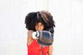 Beautiful Afro-American woman with boxing gloves claiming women`s rights against mistreatment and breast cancer. Concept of women