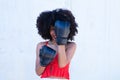 Beautiful Afro-American woman with boxing gloves claiming women`s rights against mistreatment and breast cancer. Concept of women