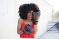 Beautiful Afro-American woman with boxing gloves claiming women`s rights against mistreatment and breast cancer. Concept of women