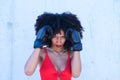 Beautiful Afro-American woman with boxing gloves claiming women`s rights against mistreatment and breast cancer. Concept of women