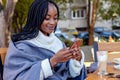 Beautiful Afro American woman chatting on her cell phone in a cafe. Royalty Free Stock Photo