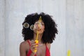 Beautiful afro american woman making soap bubbles in the park. The woman is having a great time with the bubbles and that`s why Royalty Free Stock Photo