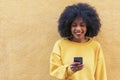 Beautiful afro american woman using mobile in the street. Royalty Free Stock Photo