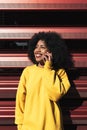 Beautiful afro american woman using mobile in the street Royalty Free Stock Photo