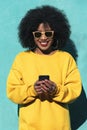 Beautiful afro american woman using mobile in the street. Royalty Free Stock Photo