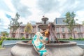 A beautiful Afro-descendant woman posing sitting and sunbathing near a water fountain in the city of San Jose in Costa Rica