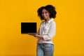 Beautiful Afro Woman Demonstrating Laptop Computer With Black Blank Screen