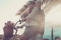 Beautiful aged couple of senior in vacation go both on an old bike and enjoy the summer sunlight. tropical place and vintage van