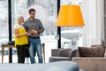 Beautiful aging mother choosing new furniture with attractive brown-haired son