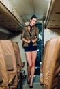 Beautiful air hostess in an airplane smiling. Traveling and jet plane flying. Air hostess. Charming stewardess dressed Royalty Free Stock Photo