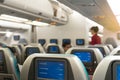 Beautiful air hostess or fight attendant waiting for service passengers on board in interior aircraft. Royalty Free Stock Photo