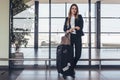 Beautiful airhostess standing in her uniform with her bags ready for a flight