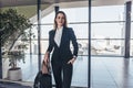 Beautiful airhostess standing in her uniform with her bags ready for a flight Royalty Free Stock Photo