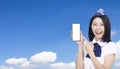 Beautiful Airline stewardess showing the mobile phone with blank screen on cloud background