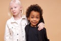 Beautiful albino girl with little african boy isolated