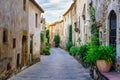 Beautiful alley with old stone houses and pots on the street with plants and flowers, Monells, Girona, Catalonia. Royalty Free Stock Photo