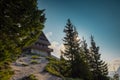 Beautiful alpine hut on Golica mountain visible from below.Nice forest in the background. Slovenian alpine cottages surrounded by Royalty Free Stock Photo