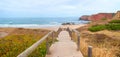 beautiful Amado beach, with boardwalk, red cliffs and mediterranean plants. surfer spot Algarve Royalty Free Stock Photo