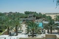 Beautiful amazing view of swimming pool surrounded by palm trees at luxury arabic desert resort Royalty Free Stock Photo