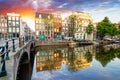 Beautiful Amsterdam sunset. Typical old dutch houses on the bridge and canals in spring, Netherlands