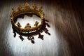 Beautiful ancient crown on wooden table, space for text. Fantasy item