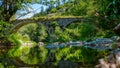 Beautiful ancient stone bridge with 2 arches, called Devil's Bridge in a green forest.  Roman architecture. Royalty Free Stock Photo