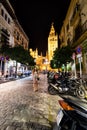 A woman walks down the streets of Seville, Spain at night