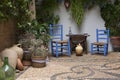 Beautiful Andalusian patio with plants, blue chairs, wooden table and vases placed on a mosaic stone floor. Cordoba, Andalusia, Royalty Free Stock Photo