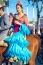 Beautiful andalusian young woman with traditional dress riding horses at the Seville`s April Fair, Seville Fair Feria de Sevilla