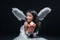 Beautiful Angel Girl offering Christmas present. Young woman with white wings in heaven style Royalty Free Stock Photo