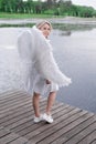 beautiful angel in white dress. Amazing blond woman with long curly hair and white wings. Royalty Free Stock Photo