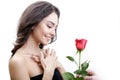 Beautiful angry girl receives one red rose. She is surprised, looking at the flowers and smiling. Royalty Free Stock Photo