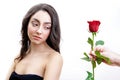 Beautiful angry girl receives one red rose. She is surprised, looking at the flowers and starts smiling. Royalty Free Stock Photo