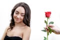 Beautiful angry girl receives one red rose. She is surprised, looking at the flowers and starts smiling. Royalty Free Stock Photo