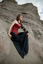 Beautiful anime woman in the sand. Red corset on the girl`s body. Bright red makeup on the face Royalty Free Stock Photo