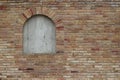 Beautiful antique brick wall texture sprinkled with hot pepper hued bricks of red, tan, pink and brown, with arched window Royalty Free Stock Photo